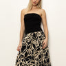 A person with long blonde hair models Sanctuary Clothing's "meet me at sea" midi dress in black mirage, set against a plain white background.