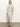 A woman with straight, shoulder-length blonde hair and a neutral expression wears the Sanctuary Clothing perfect tee maxi dress in chalk black stripe and black sandals, standing against a plain background.