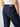 A person wearing The Marine Magnetic dark blue denim jeans by Sanctuary Clothing and a white top is shown from the back. The jeans feature two large back pockets and are secured with a belt. The contrast stitching and the denim texture are clearly visible.