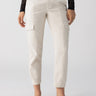 A person is wearing the Polished Cargo Pant in Toasted Marshmallow by Sanctuary Clothing, paired with a black, long-sleeved lace top. The outfit is completed with black, pointed-toe flats. Only the lower half of the person's body is visible against a plain background.