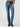 A person wears Sanctuary Clothing's Sculpted Hayden Bootcut Lucky Streak jeans, which feature front pockets and visible stitching. They pair the high-waisted blue jeans with a beige and black striped sweater, completing the look with black pointed-toe shoes. The background is light gray.