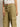 A person stands against a plain background, wearing Sanctuary Clothing's Take Over Linen Jogger Standard Rise Pants in bamboo with visible pockets, paired with a white tied crop top, showcasing only the lower half of their body.