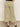 A person wearing Sanctuary Clothing's area standard rise pant bamboo—high-waisted, wide-leg light olive cargo pants with large back and side pockets—paired with black heeled sandals and one hand in a pocket.