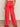 A person in Sanctuary Clothing's Highland Wide Leg Standard Rise Pant in Cayenne stands with their back to the camera, wearing a patterned top against a neutral background.