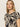 A person with long, straight hair wearing Sanctuary Clothing's "the perfect tee mirage," featuring a beige and black abstract pattern, looks calmly at the camera against a plain, light background.