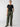 A person is standing against a plain background, wearing the Sequin Perfect Tee Black from Sanctuary Clothing and olive green cargo pants with drawstrings. They have one hand in a pocket of the pants and are wearing black flat shoes. Their hair is pulled back.