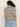 A person with long curly hair wears the Perfect Textured Tee in macrame black stripe from Sanctuary Clothing paired with light blue jeans. They stand against a neutral background, facing away from the camera.