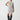 A person stands against a plain white background, wearing the Life Is Easy Swtr Dress Chalk Black Stripe by Sanctuary Clothing. They are also wearing tall, black boots and have their hand on their hip.