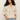 A person with long, curly hair wears a flower pop open stitch jacket in eco natural by Sanctuary Clothing, paired with light blue jeans. Their hands rest in their jean pockets as they stand against a plain background.