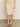 A person wears the Sanctuary Clothing sequin pencil skirt in sandstone with black sandals, standing on a light floor against a neutral wall. Only their lower half is visible.