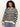 A woman with curly hair wears the Sanctuary Clothing open knit bomber jacket in black stripes (extended sizing), paired with light blue jeans, standing against a plain light background.