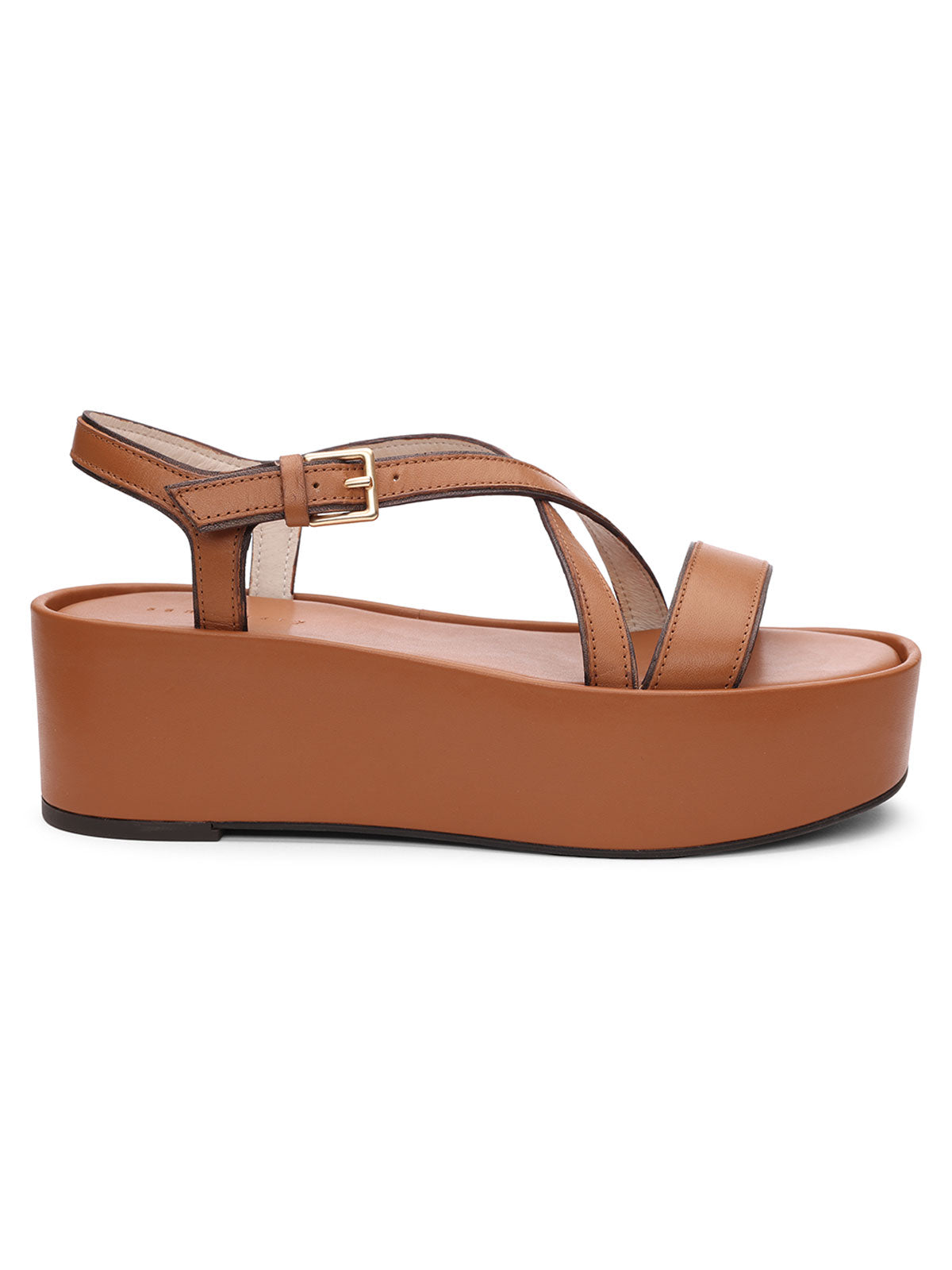 Introducing the Define Sandal Deep Honey by Sanctuary Clothing: A modern and minimalist platform sandal featuring a thick sole, crisscross straps over the toes, and an ankle strap adorned with a small gold buckle. The flat, slightly cushioned sole provides both added height and comfort.