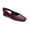 The Kitchy Slingback Flat Oxblood by Sanctuary Clothing is a women's maroon leather flat shoe with a pointed toe. It features a small buckle strap at the back and has a smooth finish. The flat sole is black, with an interior lining that also appears to be black.