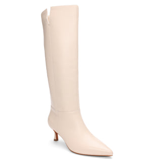 The Phoenix Tall Boot Milk by Sanctuary Clothing is a cream-colored, knee-high boot with a pointed toe and mid-height stiletto heel, showcased against a plain white backdrop. The top of the boot has a slight asymmetrical cut.