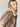 An individual with long, blonde hair is wearing the Zarina Shearling Coat in Mink Beige by Sanctuary Clothing. They are gazing directly at the camera against a plain background.