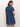 A woman with light brown hair and hoop earrings models the Sanctuary Clothing denim shiftdress in medium wash, shown from the back against a plain, light background.